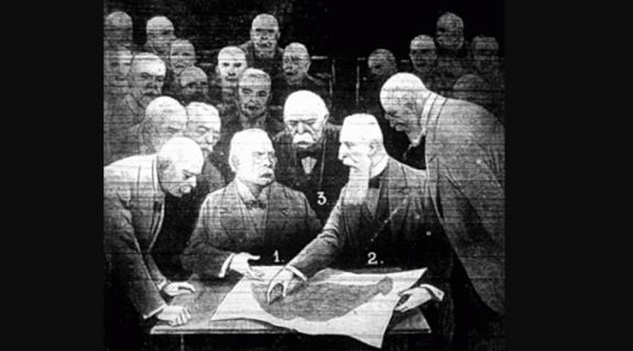 Hatalmasságok a Magyar királyság térképe fölött. Az asztalnál ülnek Lloyd George és Apponyi föléjük hajol középen Clemenceau