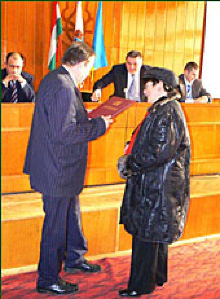 Cséke Ilona KMKSZ-képviselő átveszi kitüntetését Csizmár Bélától